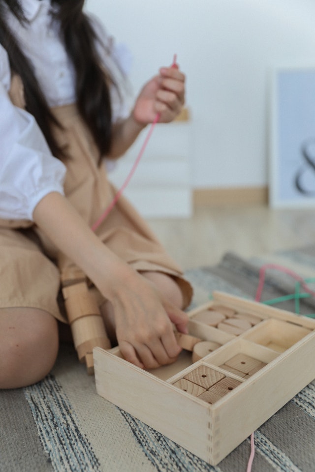 Girl playing with wood toy